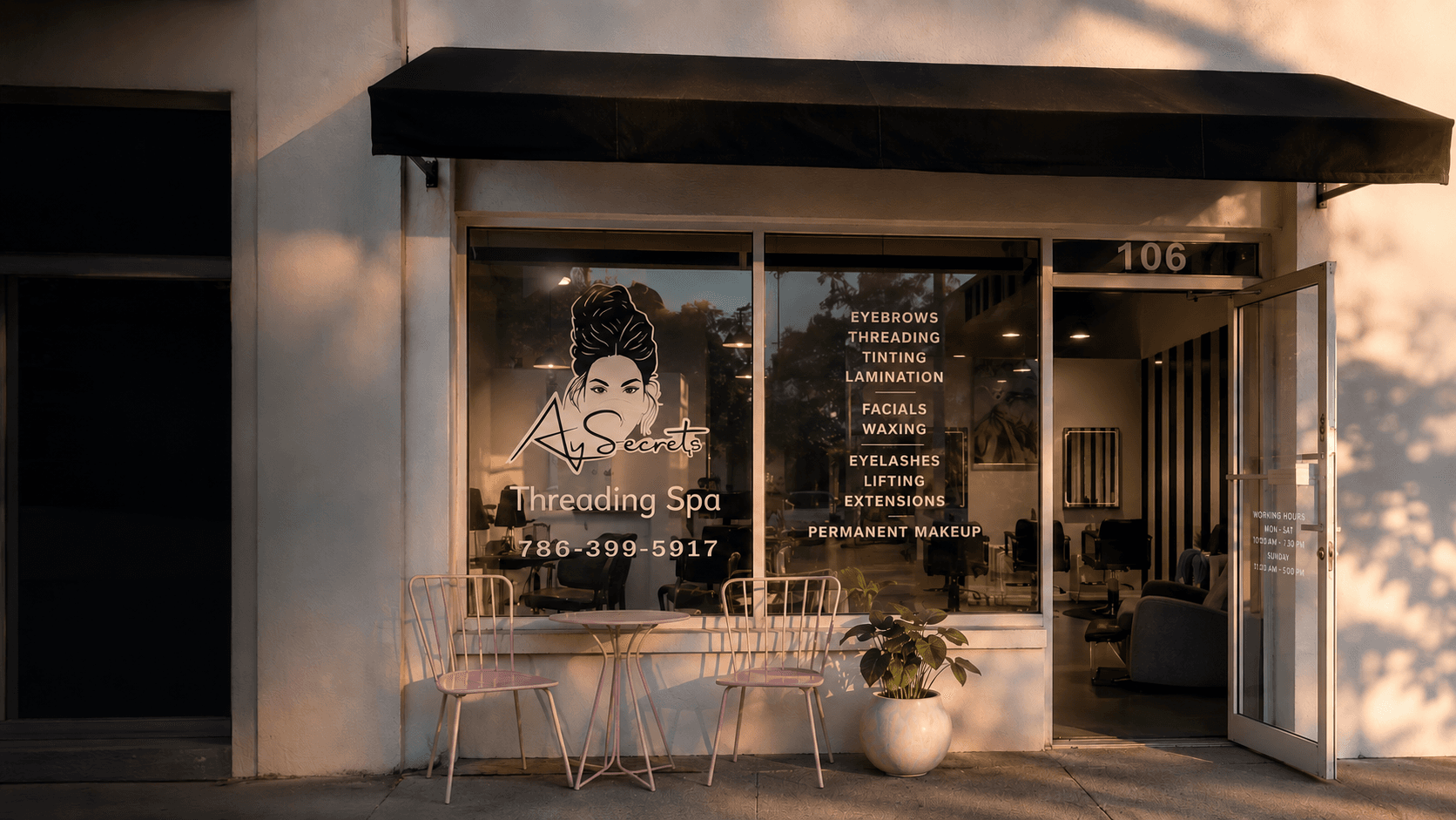 The AySecrets Threading Spa storefront at golden hour, with the pink bistro table outside the window.